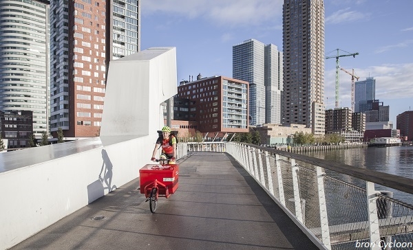 Duurzaam bezorgen van relatiegeschenken - duurzaam-bezorgen-van-relatiegeschenken-fietskoerier_in_stad_met_bron Duurzaam bezorgen van relatiegeschenken - duurzaam-bezorgen-van-relatiegeschenken-fietskoerier_in_stad_met_bron